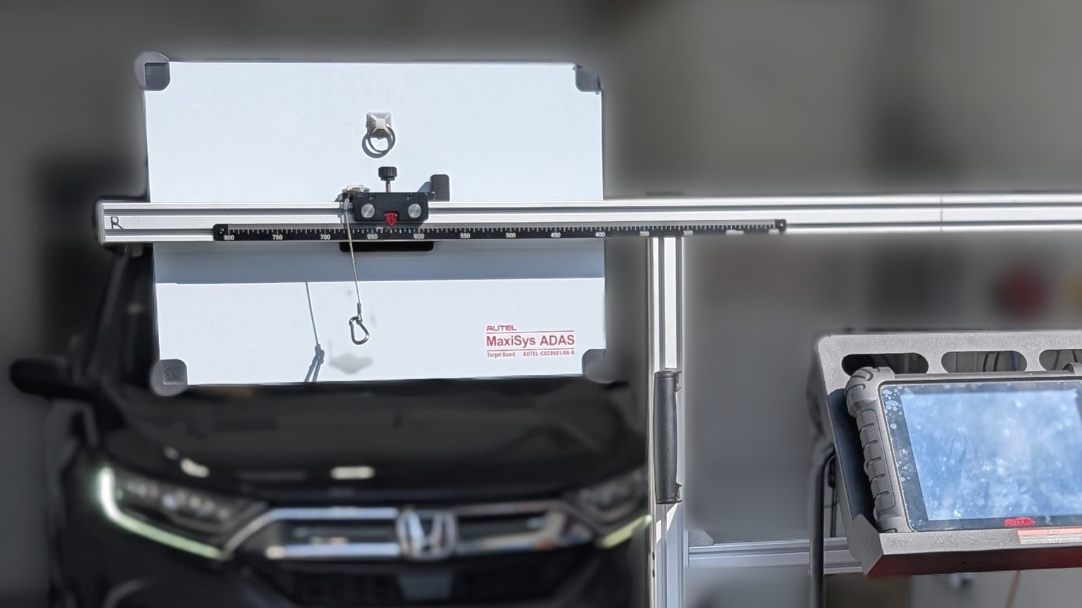 Autel MaxiSys ADAS calibration frame and target board set up in front of a Honda CR-V for a static camera calibration after a windshield replacement